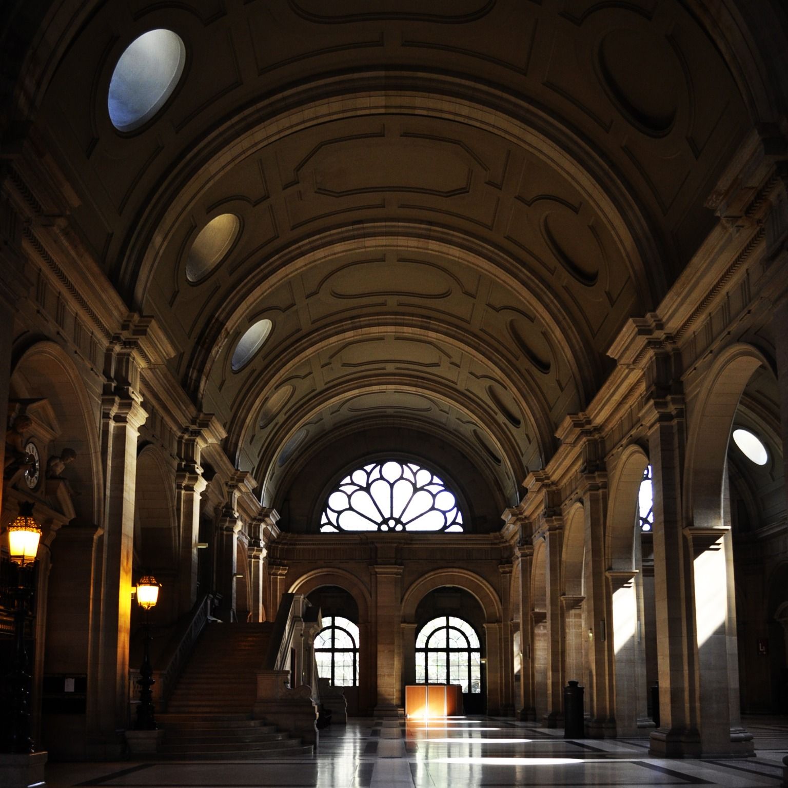 Grande salle voûtée d’un palais de justice, éclairée par une verrière en éventail