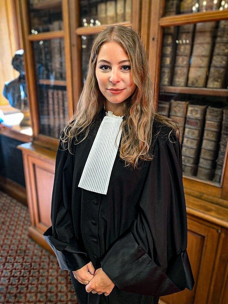 Maître Cyrielle HAMDAD en robe d’avocat, dans une bibliothèque